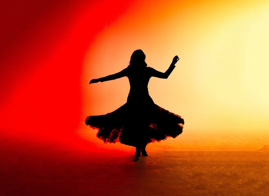 Silhouette of a woman in a dress spinning  