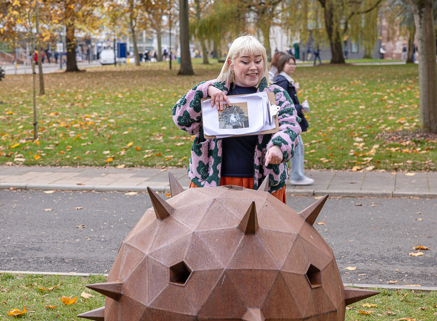 Woman pointing at a sculpture