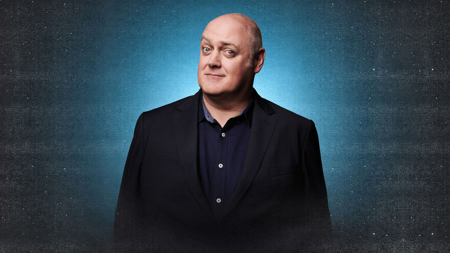 Dara O'Briain looking in a suit with a starry background