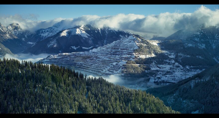 A stunning vista of trees and snow capped mountains. 